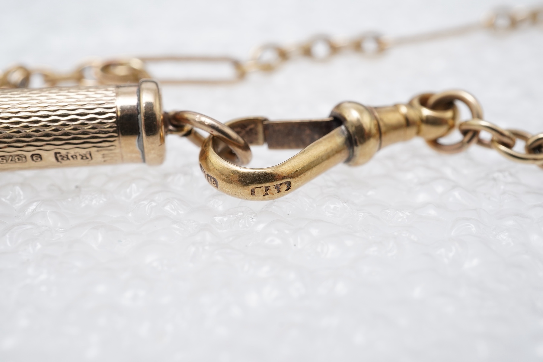 A gold watch chain, toothpick and fob seal